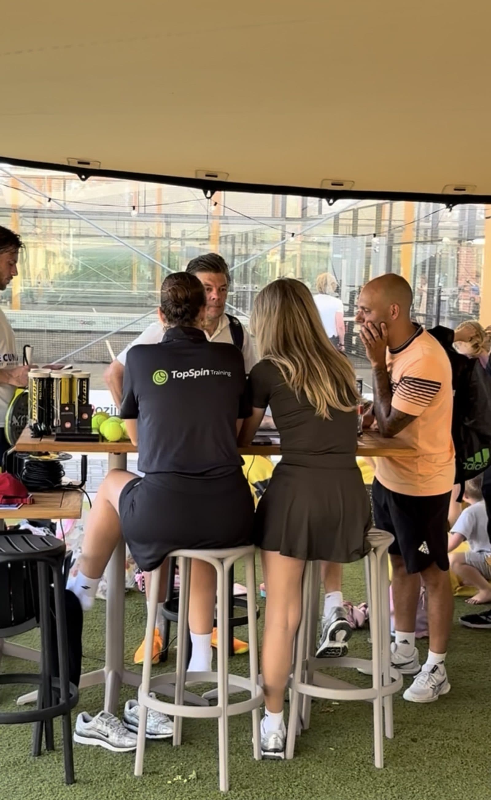 Gasten aan tafel onder de tent op het terras