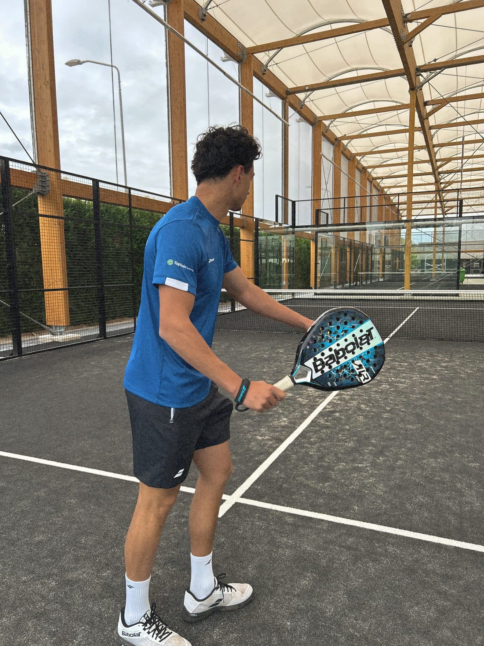 Speler op een overdekte padelbaan van TopSpinPlaza